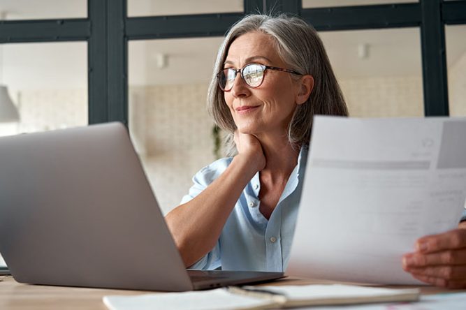 Retraitée devant son ordinateur pour déclarer ses retraites en ligne
